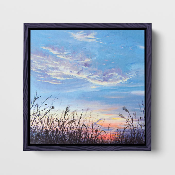 framed painting of a meadow and the sky hanging on a wall