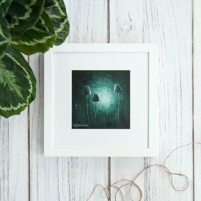 framed painting of moonlit fungi laying on the wooden floor